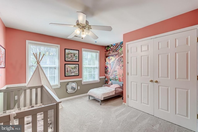carpeted bedroom featuring a closet, ceiling fan, and baseboards