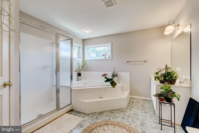 bathroom with a garden tub, a stall shower, baseboards, and vanity