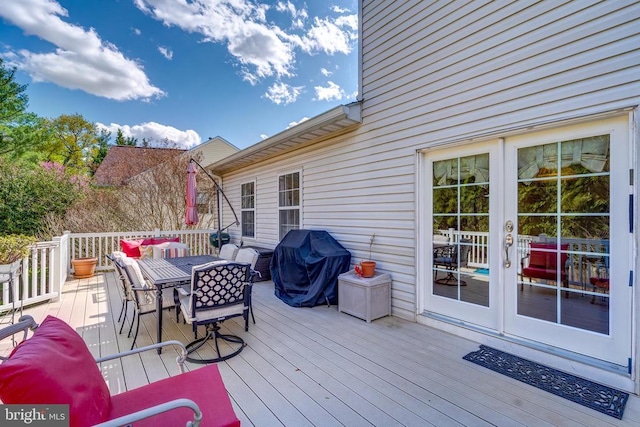 wooden terrace featuring outdoor dining area and grilling area