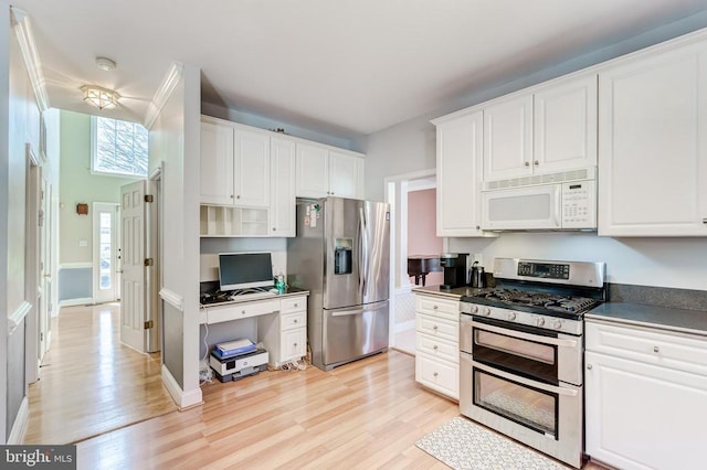 kitchen with stainless steel appliances, light wood-style floors, and white cabinetry