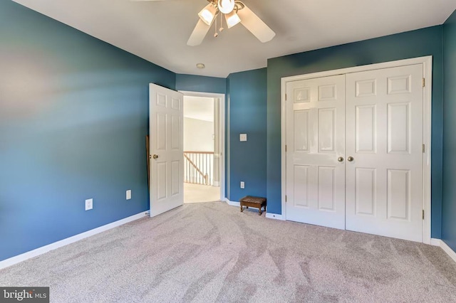 unfurnished bedroom featuring carpet floors, baseboards, a closet, and a ceiling fan