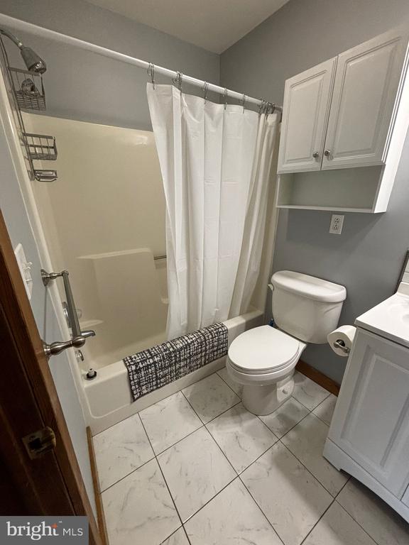 453 Lost Valley Rd, Madison, VA 22727 - full bathroom with marble look tile flooring, shower / bath combination with curtain, toilet, and vanity