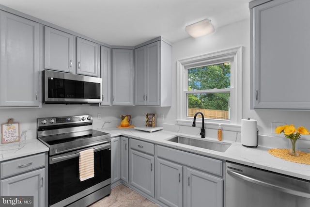 13179 Scotts Mill Rd, Culpeper, VA 22701 - kitchen featuring appliances with stainless steel finishes, a sink, gray cabinetry, and light stone counters