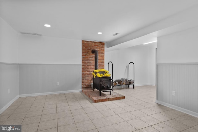13179 Scotts Mill Rd, Culpeper, VA 22701 - empty room with a wood stove, wainscoting, light tile patterned floors, baseboards, and recessed lighting