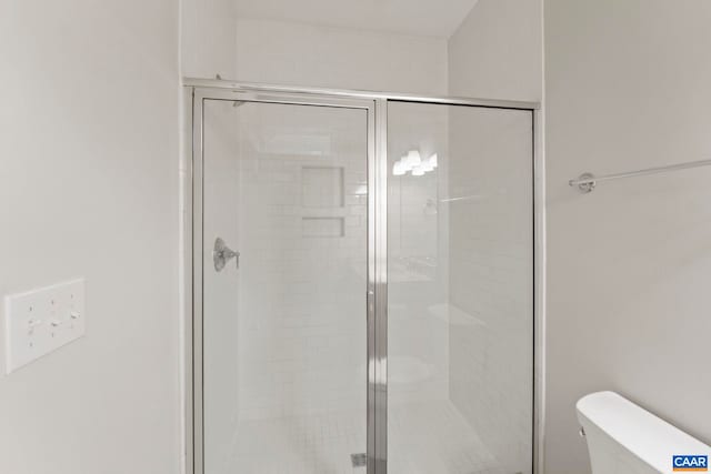 full bath featuring toilet and a stall shower