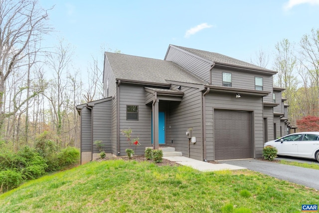 view of front of home featuring driveway, roof with shingles, a garage, and a front yard