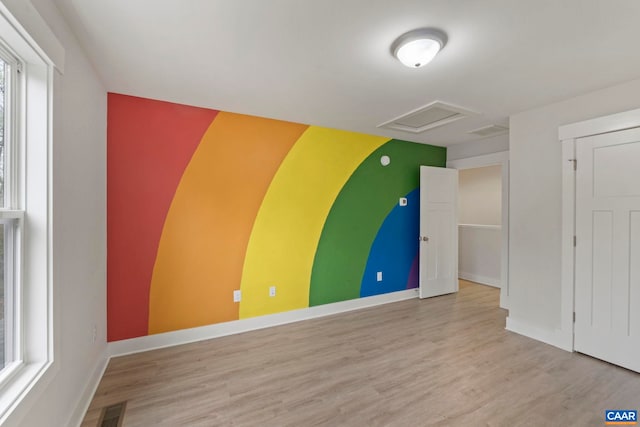 interior space with baseboards, attic access, visible vents, and wood finished floors