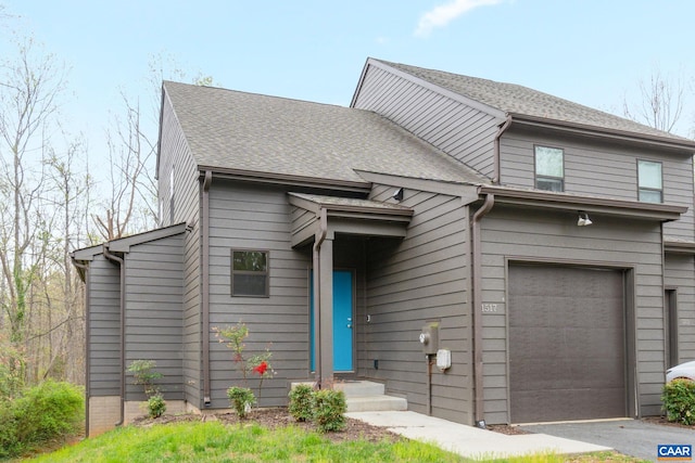 view of front of house with aphalt driveway, an attached garage, and a shingled roof