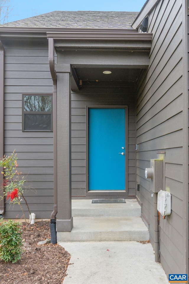 property entrance with roof with shingles