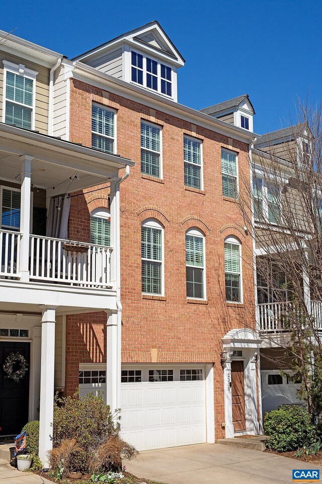 townhome / multi-family property with an attached garage and brick siding