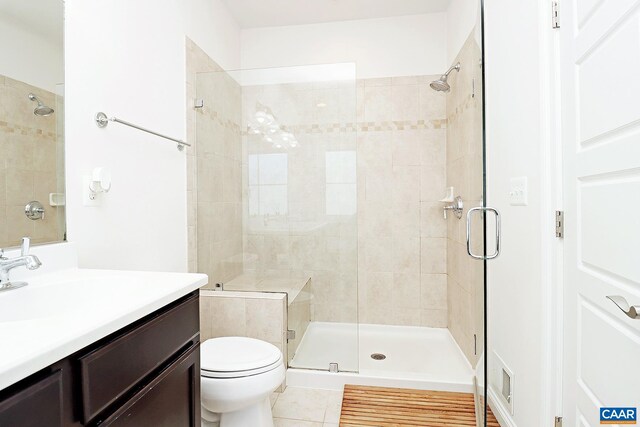 full bath featuring vanity, toilet, a shower stall, and tile patterned flooring