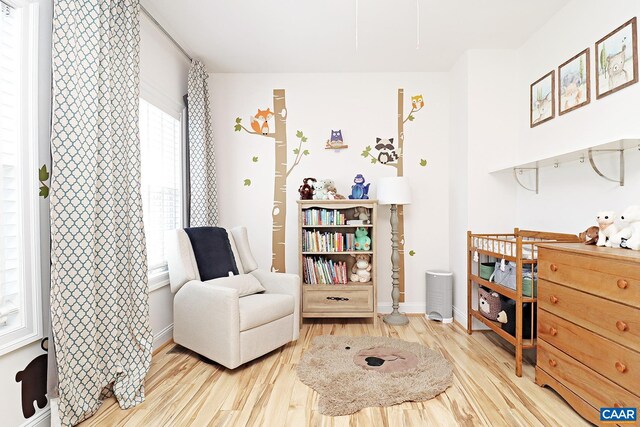 sitting room featuring baseboards and light wood finished floors