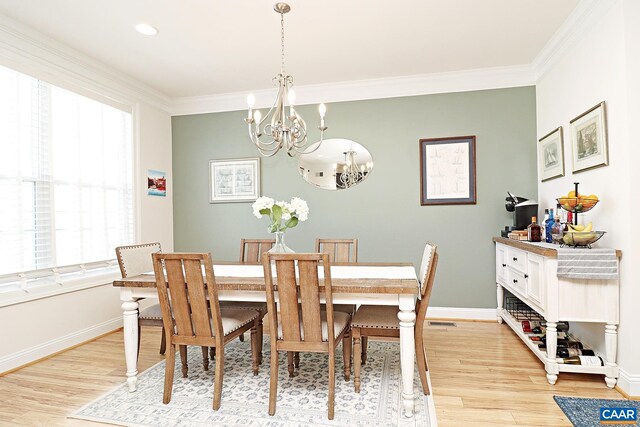 dining area with baseboards, a wealth of natural light, a notable chandelier, and light wood-style floors