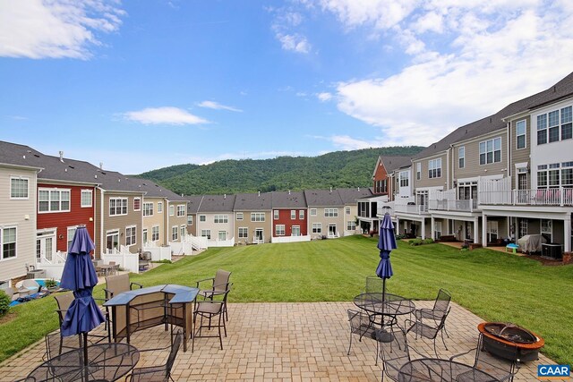 view of patio / terrace featuring a fire pit, a residential view, outdoor dining space, and central AC