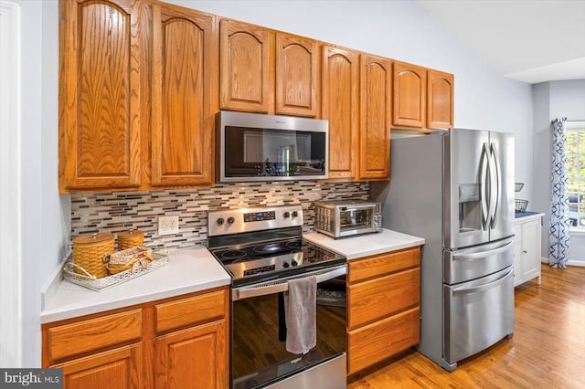 279 Carriage Ln, Madison, VA 22727 - kitchen featuring stainless steel appliances, decorative backsplash, light wood-style flooring, and vaulted ceiling