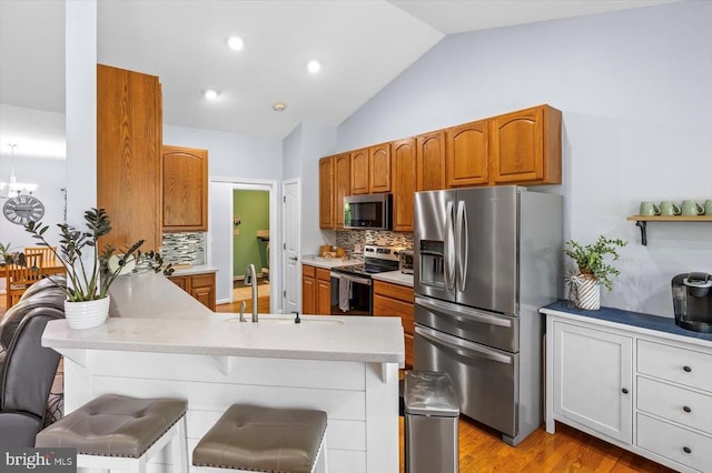 279 Carriage Ln, Madison, VA 22727 - kitchen featuring appliances with stainless steel finishes, tasteful backsplash, vaulted ceiling, a peninsula, and a sink