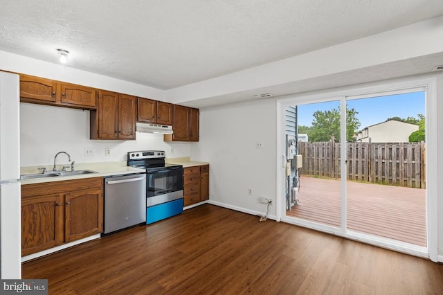 5143 Cottonwood Ct, Fredericksburg, VA 22407 - kitchen featuring appliances with stainless steel finishes, under cabinet range hood, a sink, dark wood-style floors, and light countertops
