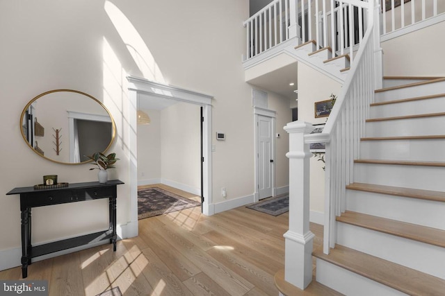 7345 Iron Bit Dr, Warrenton, VA 20186 - stairway featuring wood finished floors, a towering ceiling, and baseboards