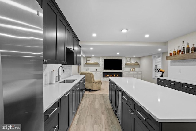 7345 Iron Bit Dr, Warrenton, VA 20186 - kitchen featuring freestanding refrigerator, a sink, a large fireplace, light countertops, and open floor plan