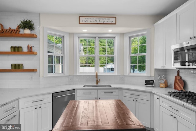 7345 Iron Bit Dr, Warrenton, VA 20186 - kitchen with appliances with stainless steel finishes, a sink, backsplash, white cabinetry, and open shelves