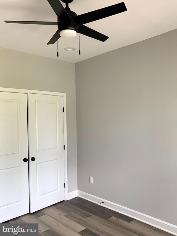 15477 Norman Rd, Culpeper, VA 22701 - unfurnished bedroom with dark wood finished floors, a closet, and ceiling fan