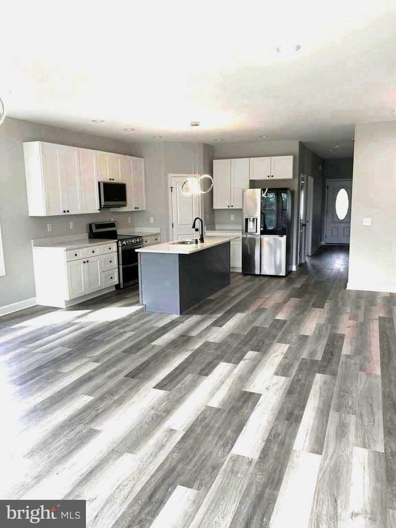15477 Norman Rd, Culpeper, VA 22701 - kitchen with appliances with stainless steel finishes, light countertops, dark wood finished floors, and white cabinets