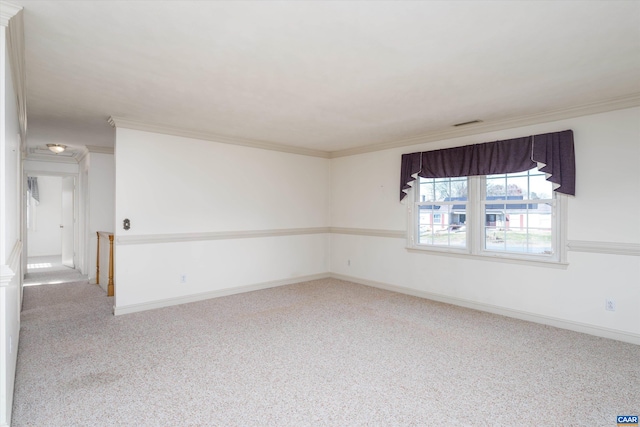 carpeted empty room with ornamental molding and baseboards