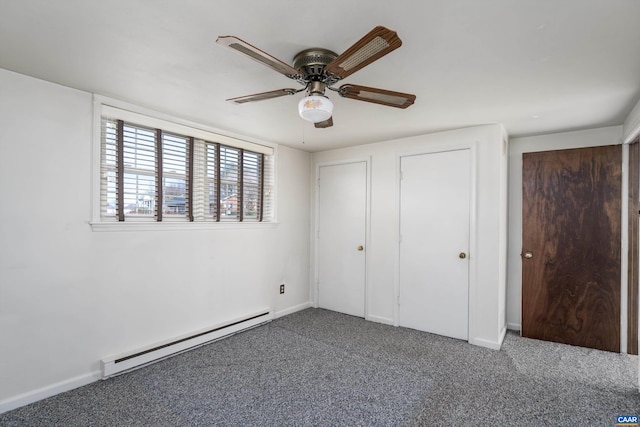 unfurnished bedroom featuring baseboard heating, baseboards, ceiling fan, two closets, and carpet floors