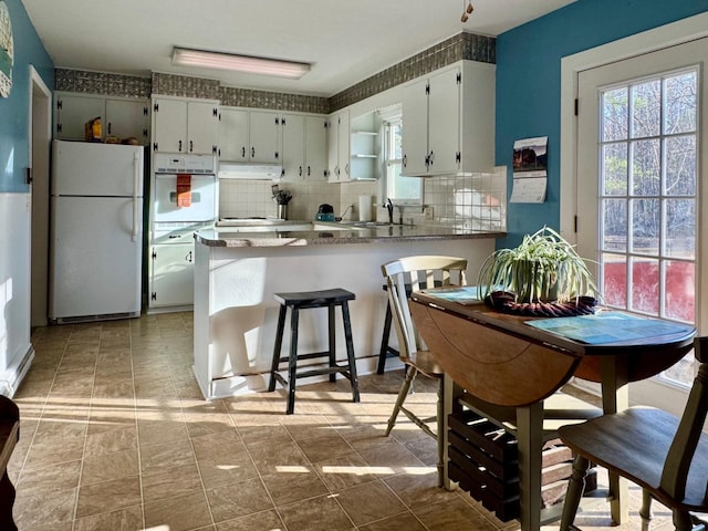 8127 Briery Branch Rd, Dayton, VA 22821 - kitchen featuring under cabinet range hood, backsplash, a healthy amount of sunlight, and white appliances