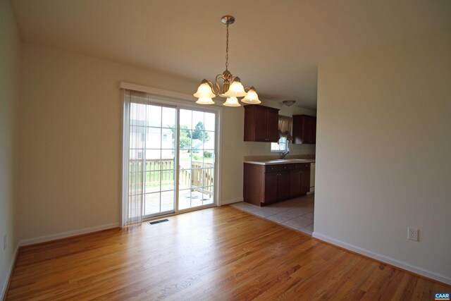10 Lady Slipper Dr, Waynesboro, VA 22980 - unfurnished dining area with a chandelier, light wood-style floors, baseboards, and a sink