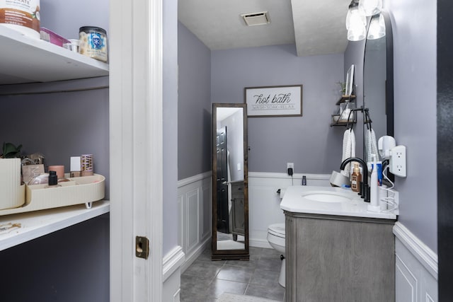 146 Harper St, Weyers Cave, VA 24486 - bathroom featuring toilet, vanity, wainscoting, and tile patterned flooring