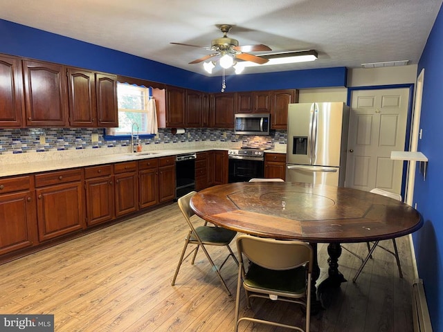 16 Park Ave, Luray, VA 22835 - kitchen with stainless steel appliances, a baseboard radiator, light wood-style flooring, tasteful backsplash, and ceiling fan