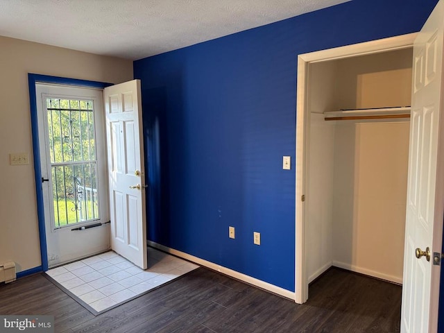 16 Park Ave, Luray, VA 22835 - unfurnished bedroom featuring wood finished floors, multiple windows, and a textured ceiling