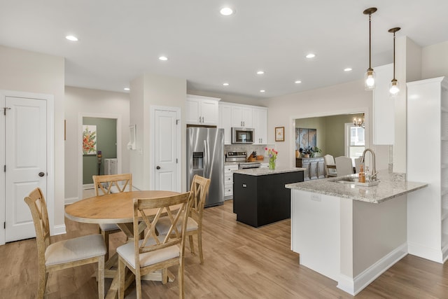141 Tomasville Dr, Waynesboro, VA 22980 - kitchen featuring light wood-style flooring, a sink, white cabinetry, a kitchen island, and stainless steel appliances