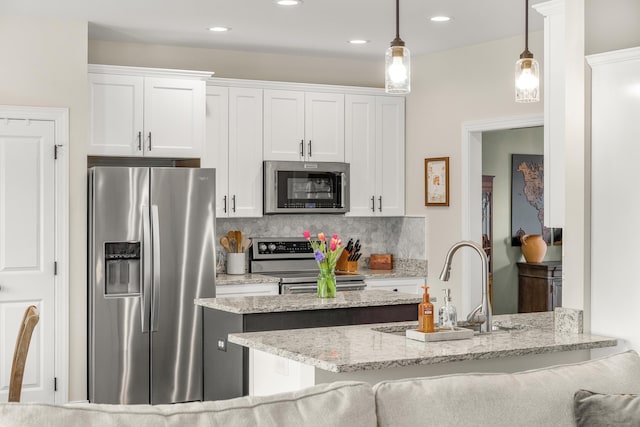 141 Tomasville Dr, Waynesboro, VA 22980 - kitchen with a sink, stainless steel appliances, pendant lighting, white cabinets, and light stone countertops