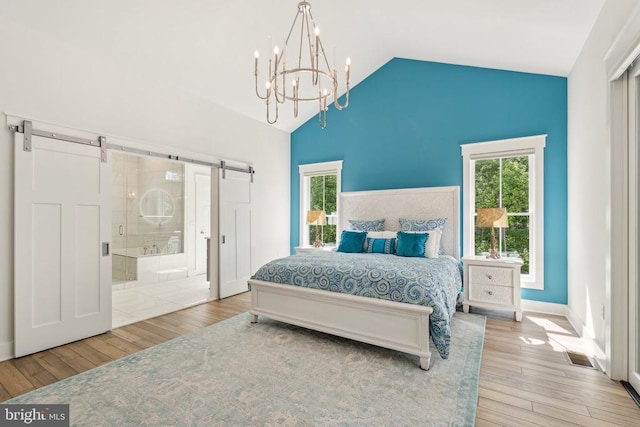 11206 Preswick Ln, Spotsylvania, VA 22551 - bedroom featuring a barn door, a chandelier, wood-type flooring, ensuite bathroom, and high vaulted ceiling