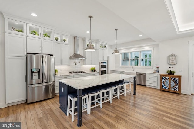 11206 Preswick Ln, Spotsylvania, VA 22551 - kitchen with stainless steel appliances, wall chimney exhaust hood, backsplash, white cabinetry, and light wood finished floors