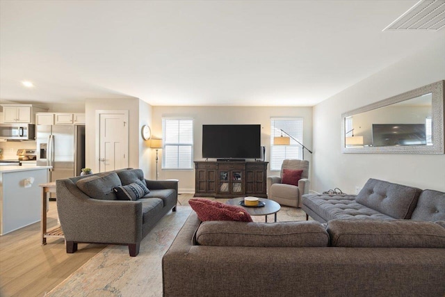 living room featuring plenty of natural light and light hardwood / wood-style flooring