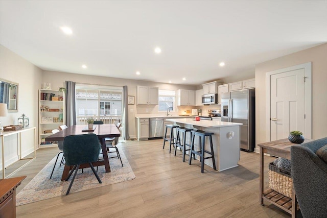 dining space with sink and light hardwood / wood-style flooring