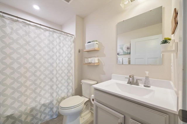 bathroom with vanity, a shower with shower curtain, and toilet