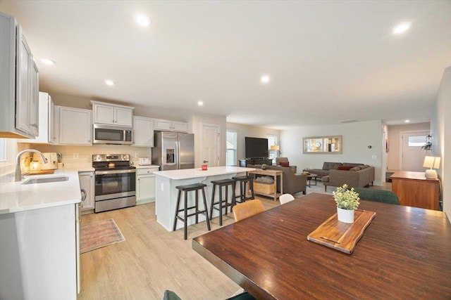 dining space with sink, a wealth of natural light, and light wood-type flooring