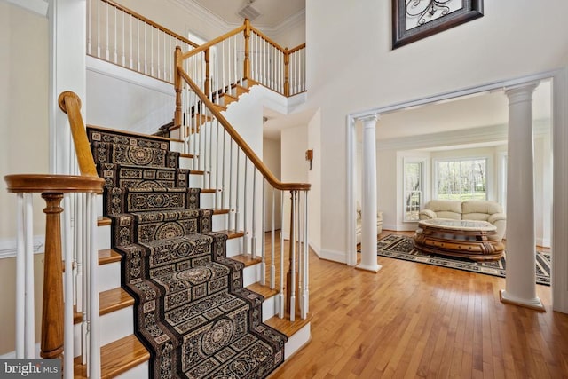 8800 General Griffins Ct, Fredericksburg, VA 22407 - stairs with decorative columns, hardwood / wood-style floors, ornamental molding, a high ceiling, and baseboards
