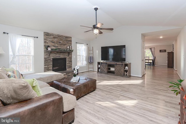 living room featuring vaulted ceiling, plenty of natural light, and light hardwood / wood-style flooring