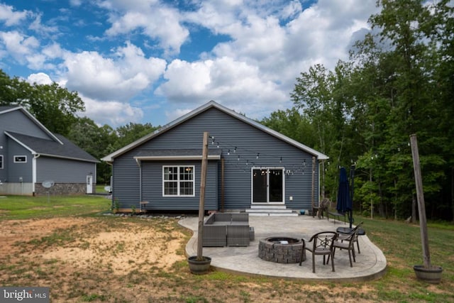 back of property with a yard, a patio area, and an outdoor fire pit