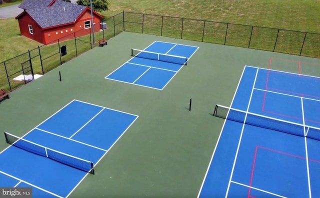 view of property's community with tennis court and a lawn