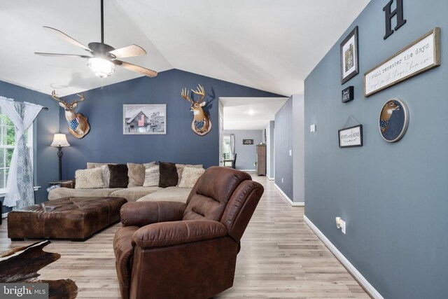 living room featuring lofted ceiling, ceiling fan, and light wood-type flooring