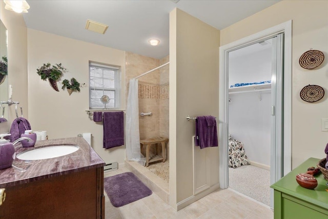 130 Rainier Rd, Mcgaheysville, VA 22840 - full bathroom with a tile shower, vanity, a baseboard radiator, a spacious closet, and baseboards