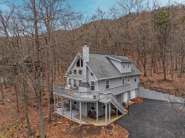 130 Rainier Rd, Mcgaheysville, VA 22840 - back of house with stairs, a chimney, roof with shingles, a garage, and asphalt driveway