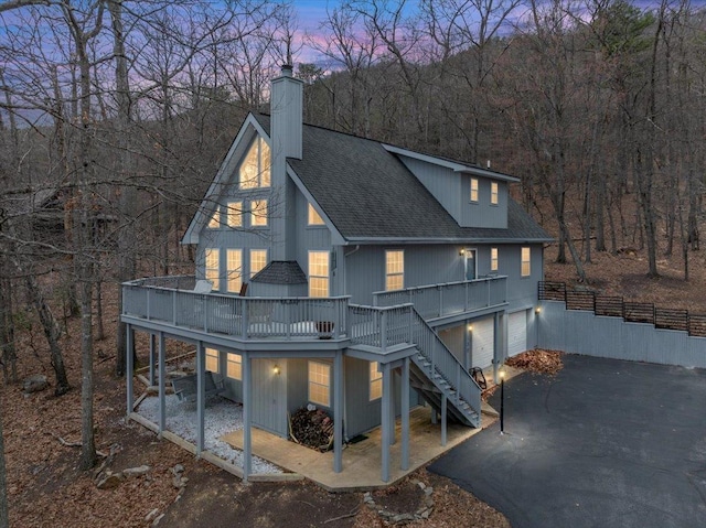 130 Rainier Rd, Mcgaheysville, VA 22840 - rear view of house with stairs, a chimney, driveway, roof with shingles, and an attached garage