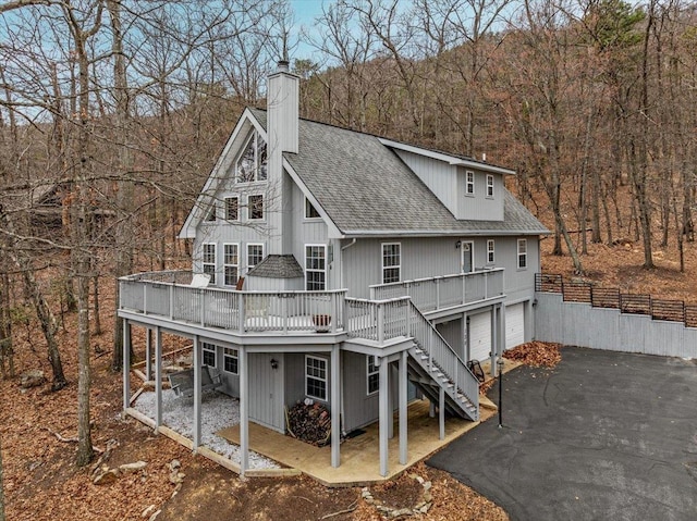 130 Rainier Rd, Mcgaheysville, VA 22840 - rear view of property featuring a deck, roof with shingles, a garage, stairway, and a chimney